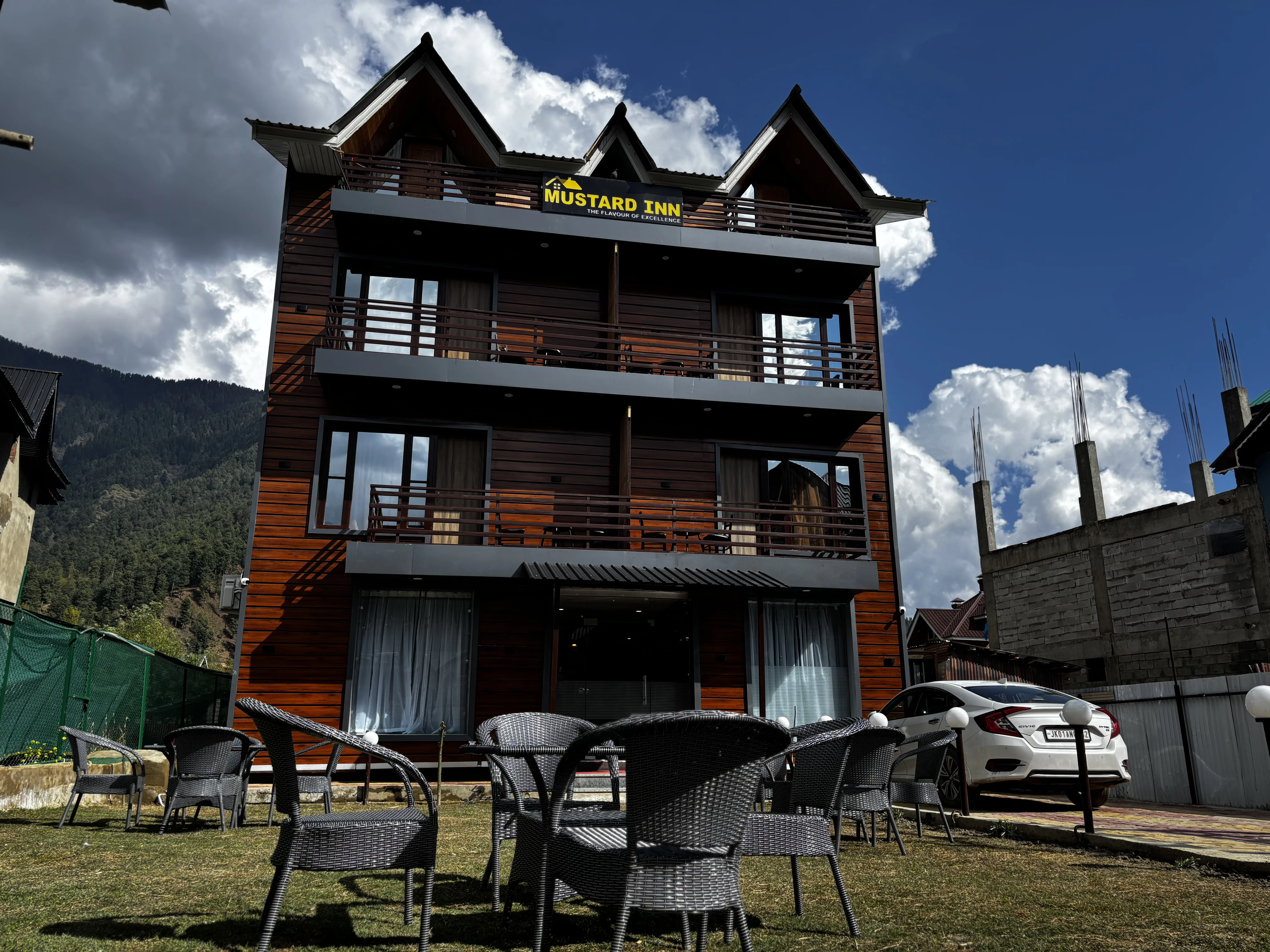 Panoramic view of Hotel Mustard Inn luxury property in Pahalgam, Kashmir with mountain backdrop